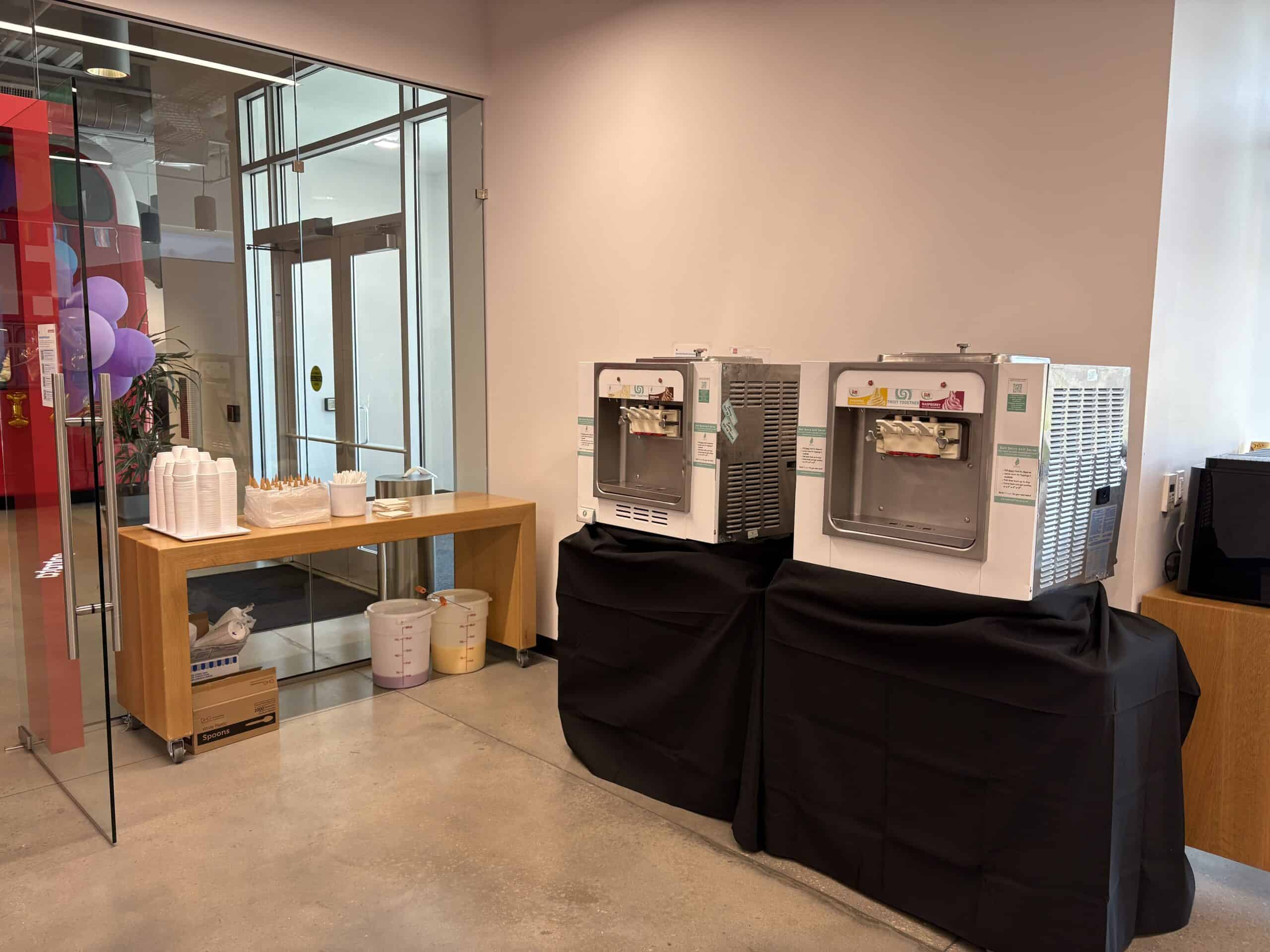 Two soft serve machines set up in an office lobby for a company event